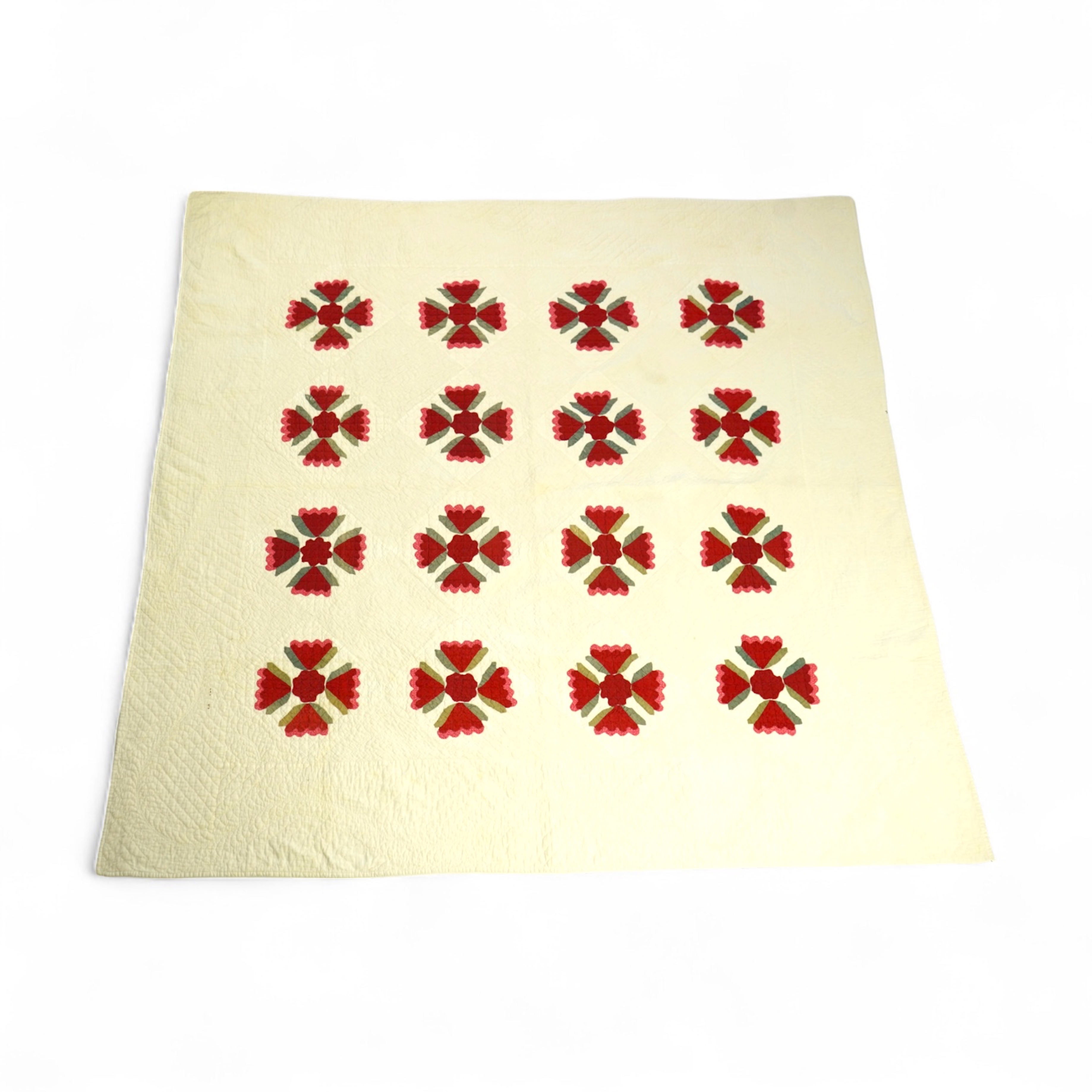 An American quilt from Kentucky, circa 1900. Intricately hand quilted on a white ground, appliquéd with stylistic repeating floral motifs in strong red and green cottons, all hand pieced. This quilt is a fine example of
